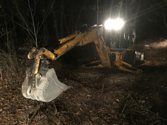 image of an excavator digging holes